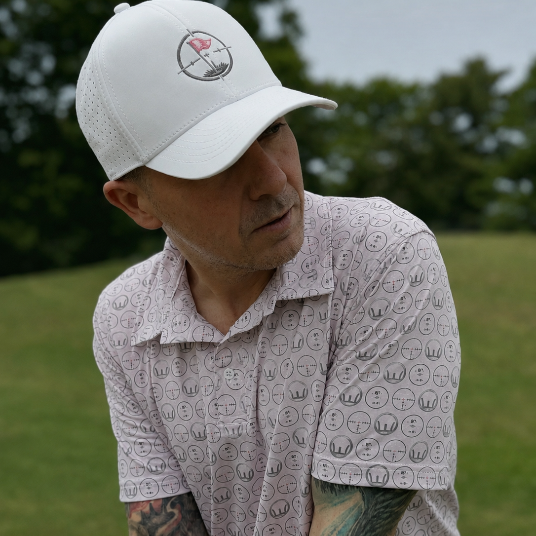 Man wearing a white cap with a logo and patterned shirt outdoors