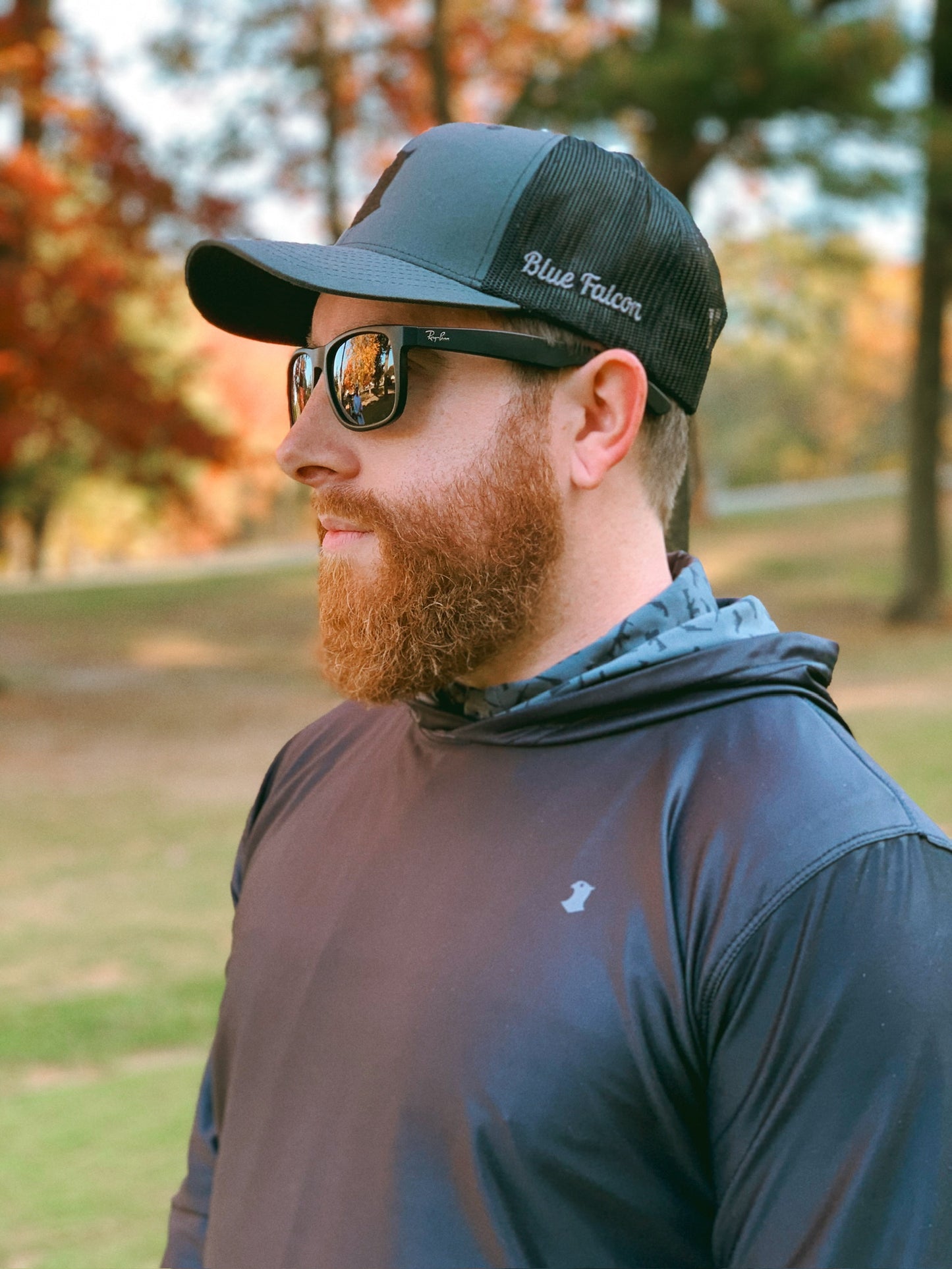 A golfer in a hat and performance hoodie, with a pop of graphic design on the inside of the hood.