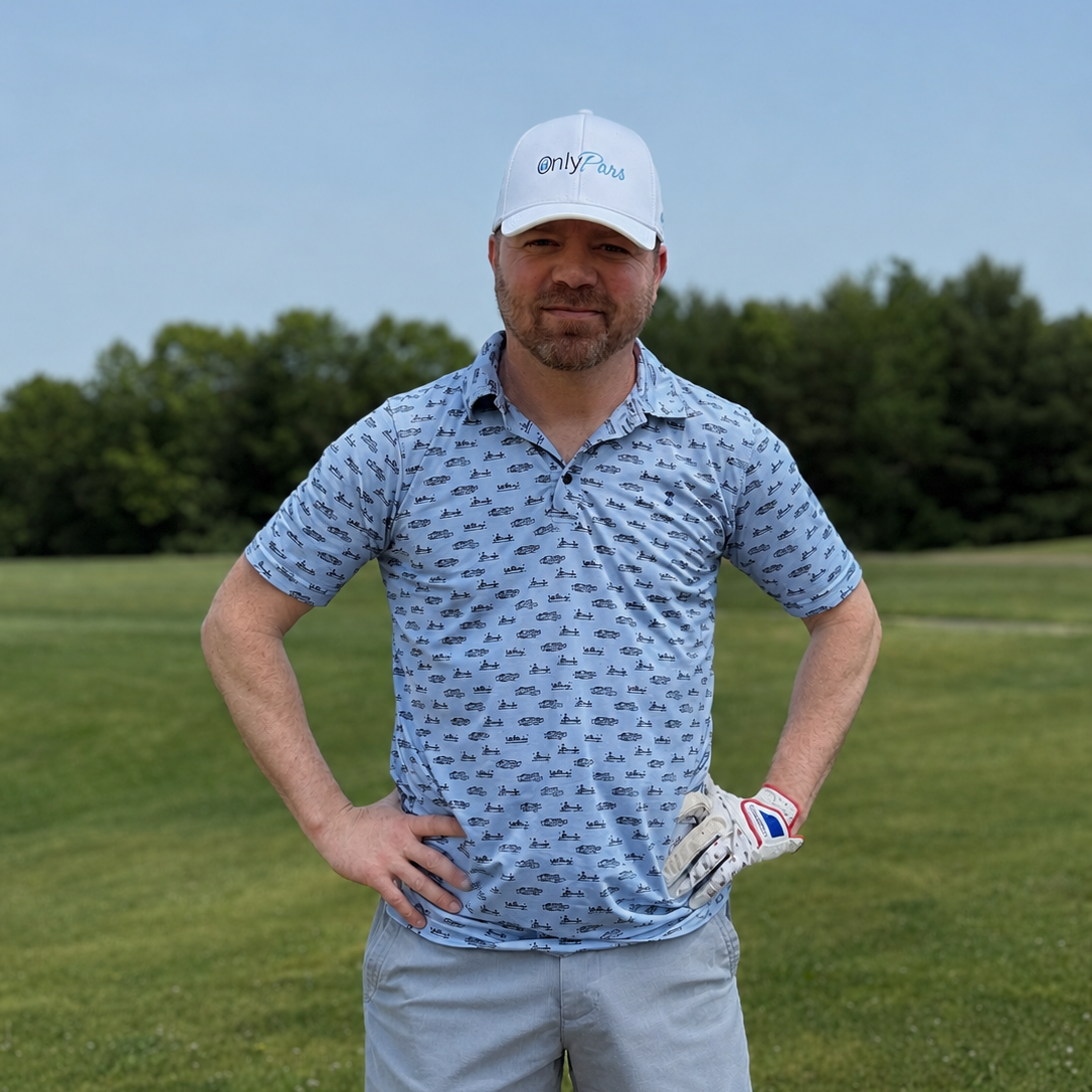 Man in golf attire standing on a golf course with trees in the background