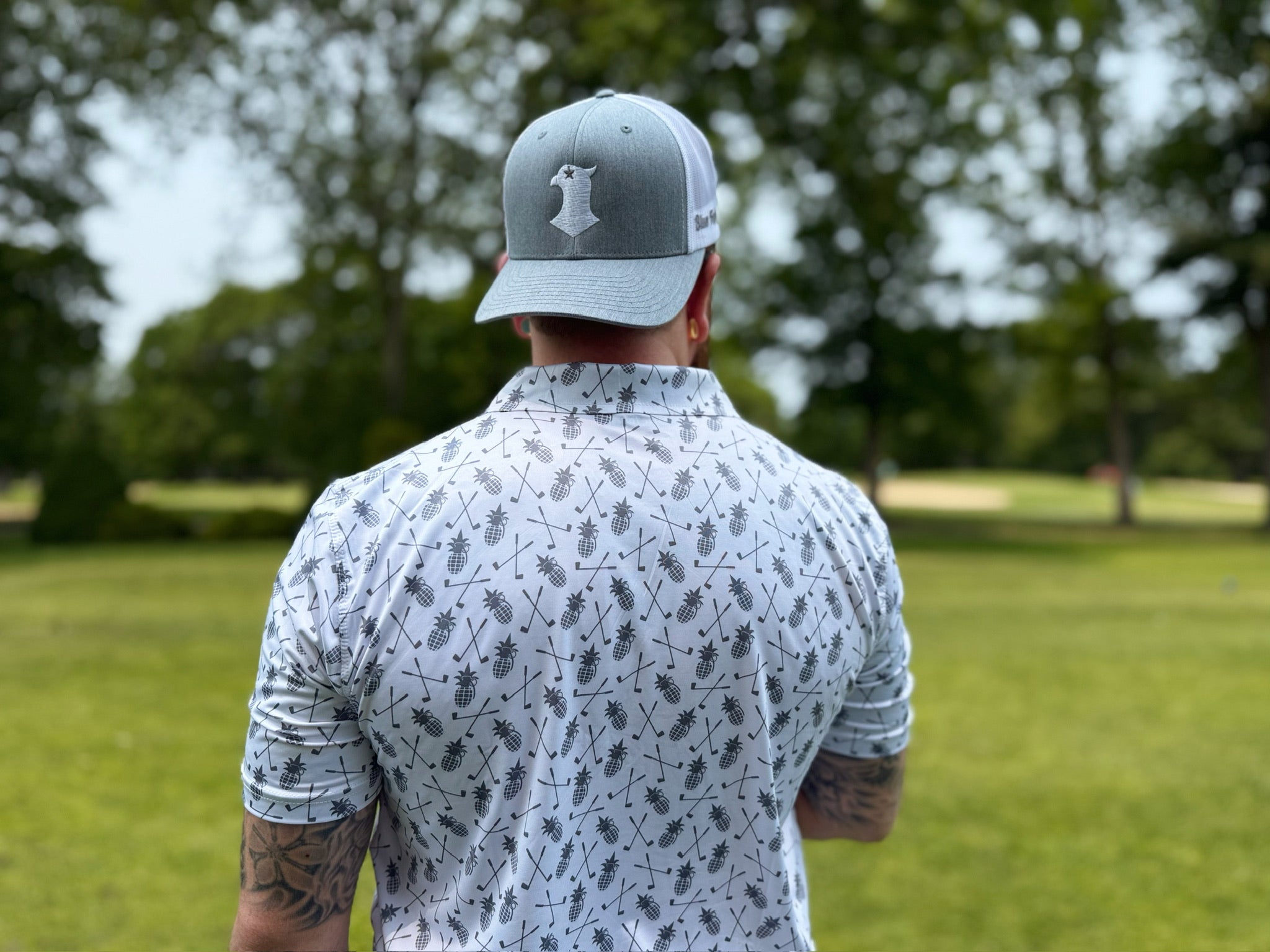 A man wearing a backwards grey and white Blue Falcon snapback hat with the 
